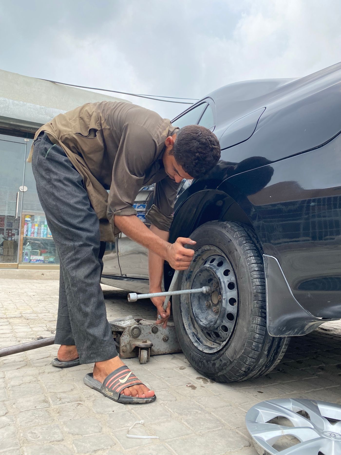 Hands working near a vehicle tire